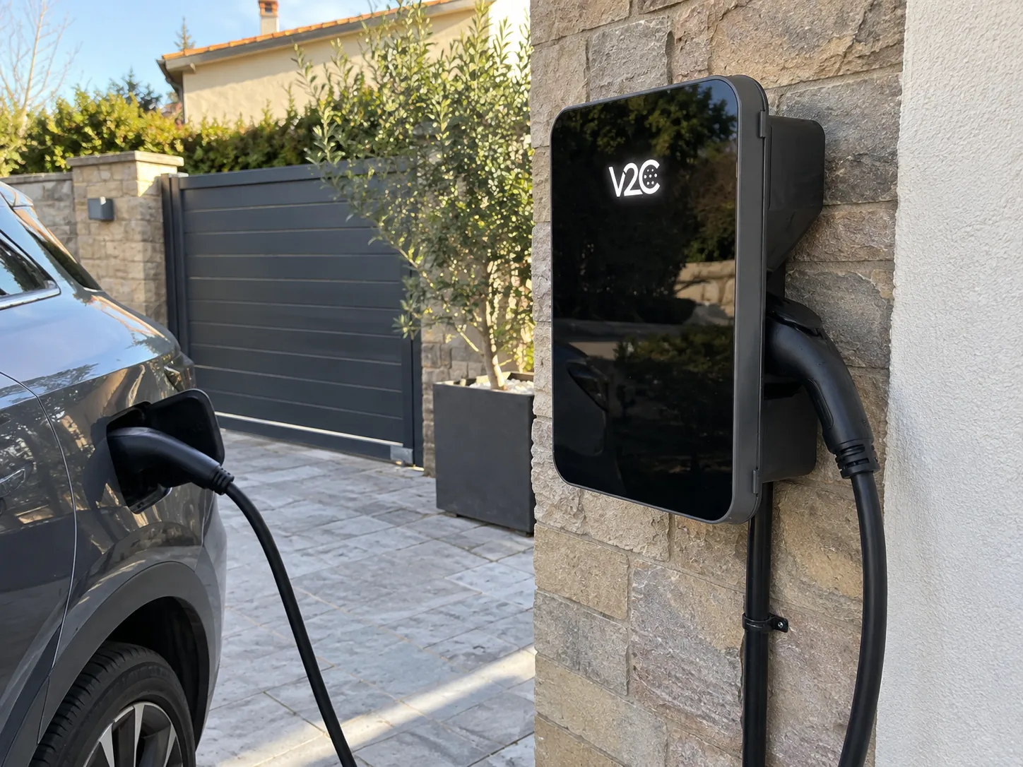 Coche eléctrico conectado a un cargador V2C instalado en el exterior de una vivienda en Galicia