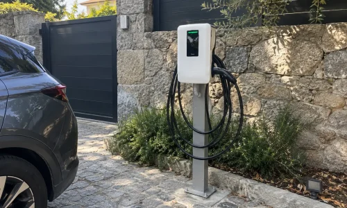 Cargador para coche eléctrico instalado sobre pedestal junto al aparcamiento de un establecimiento en Galicia